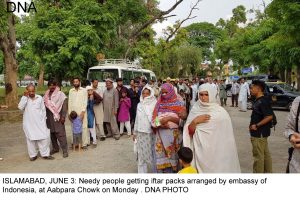 ISLAMABAD, JUNE 3: Needy people getting iftar packs arranged by embassy of  Indonesia, at Aabpara Chowk on Monday . DNA PHOTO