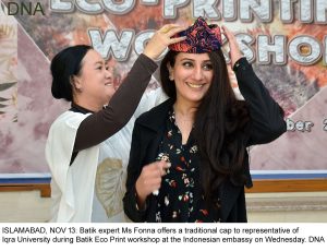 ISLAMABAD, NOV 13: Batik expert Ms Fonna offers a traditional cap to representative of Iqra University during Batik Eco Print workshop at the Indonesian embassy on Wednesday. DNA